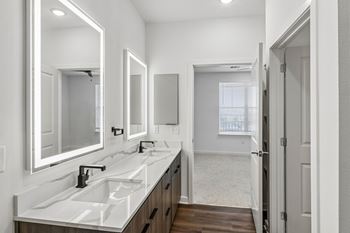 Dual vanity bathroom with backlit mirrors